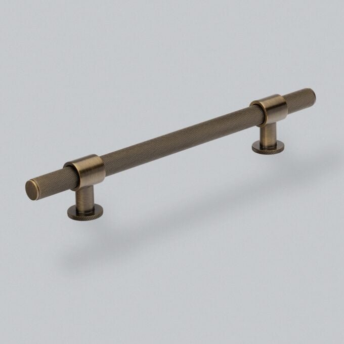 Textured bronze cabinet handle on white background.