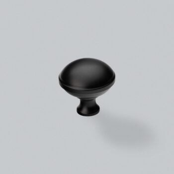 Black cabinet knob on grey background.