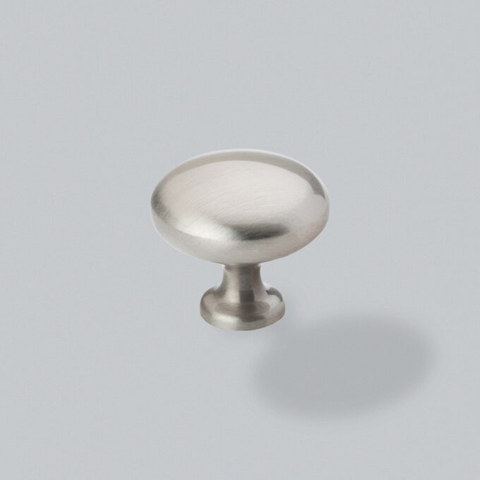 Brushed stainless steel cabinet knob on grey background.