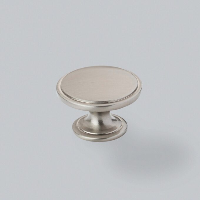 Stainless steel cabinet knob on grey background