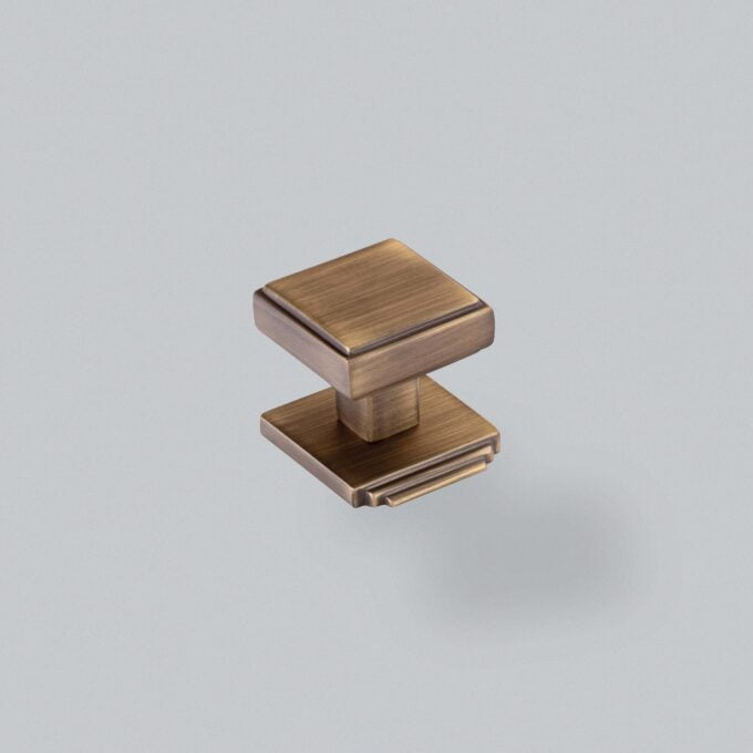 Brushed bronze cabinet knob on grey background