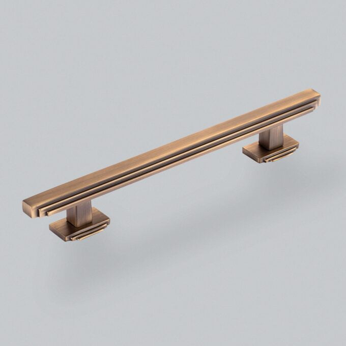 Bronze cabinet handle on a grey background.