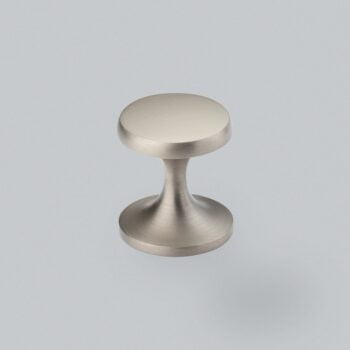 Brushed metal cabinet knob on grey background.