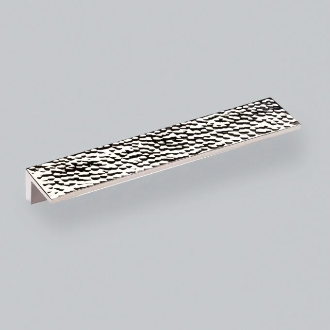 Textured silver cabinet handle on grey background