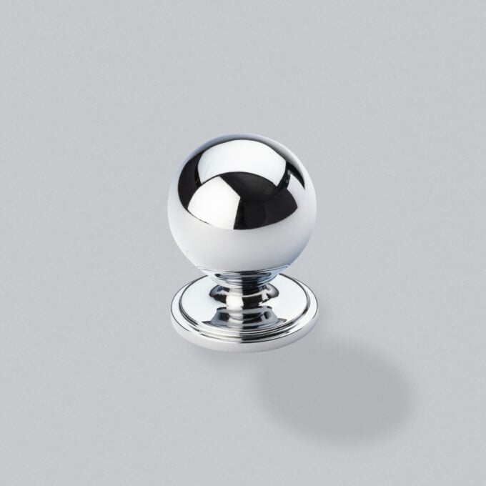 Reflective chrome spherical knob on grey background.