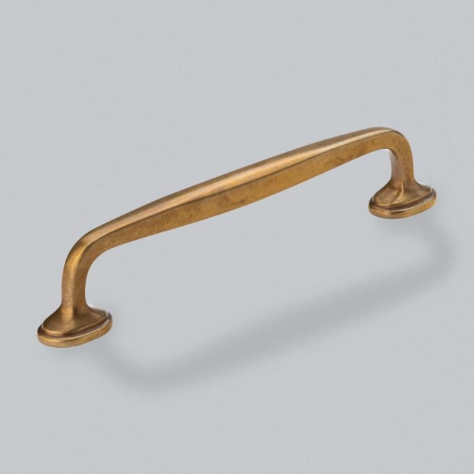 Antique bronze cabinet handle on grey background.