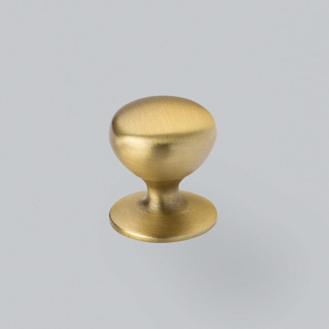 Brass door knob on grey background.