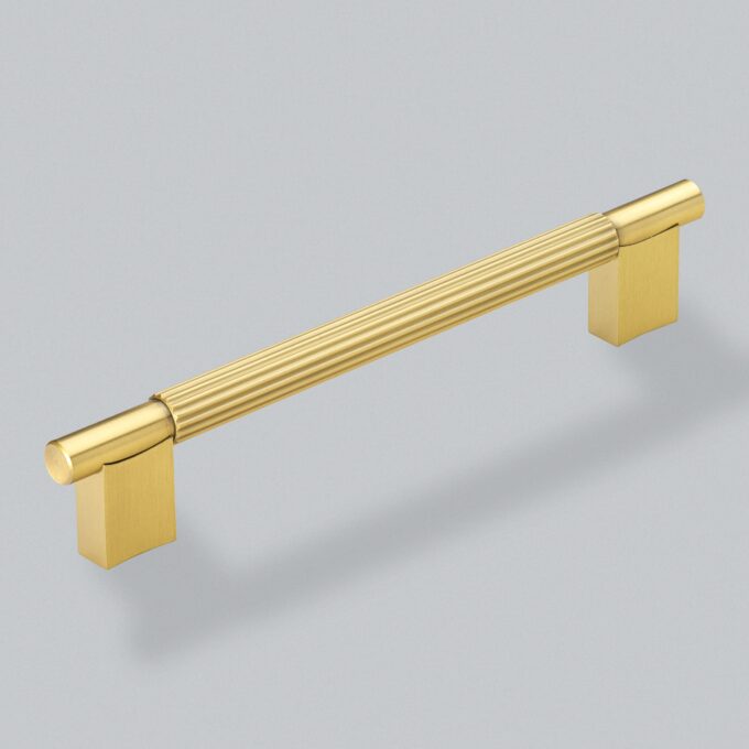 Gold cabinet handle on grey background.