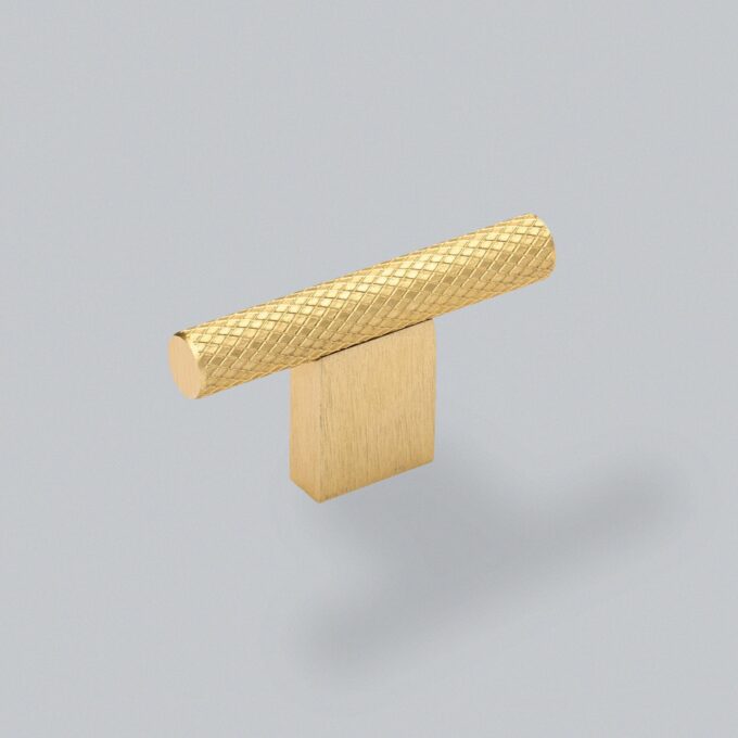 Golden textured cylindrical object on wooden base.