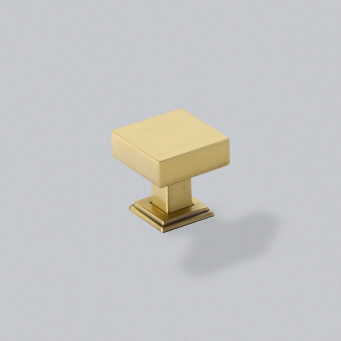 Gold geometric knob on grey background.