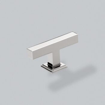 Modern chrome cabinet handle on grey background.