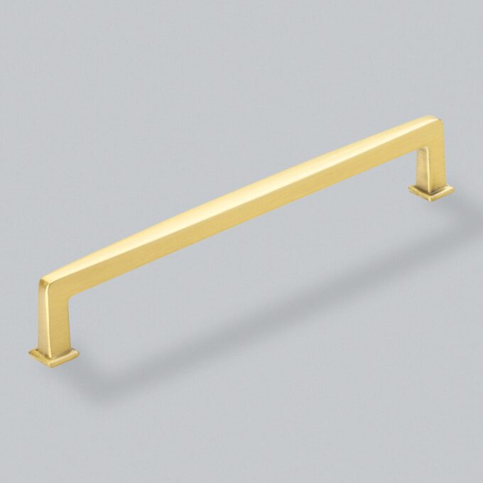 Gold cabinet handle on grey background.