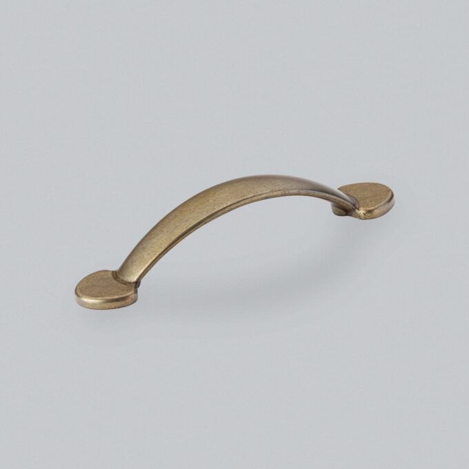 Antique brass cabinet handle on white background.