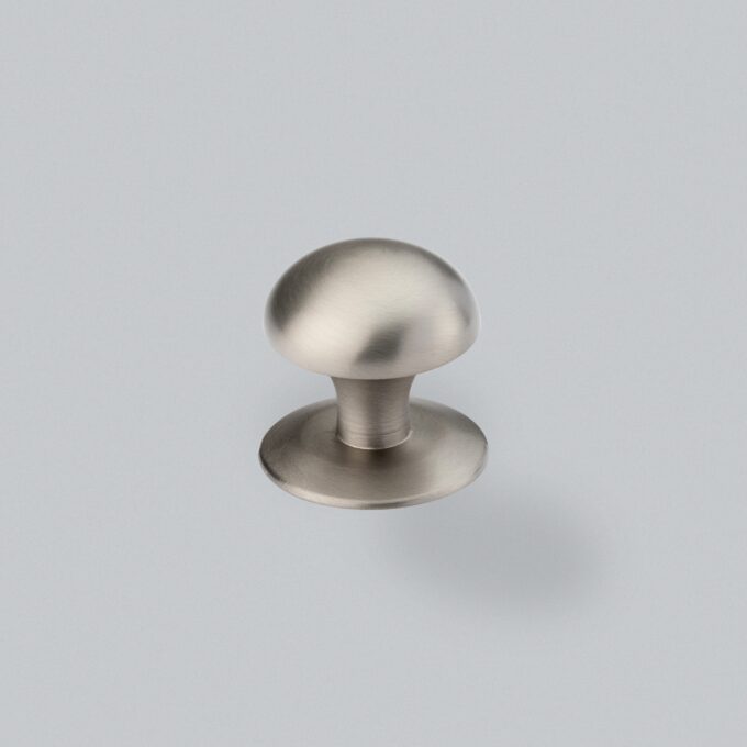 Brushed nickel cabinet knob on grey background