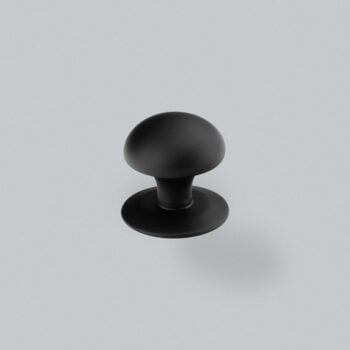 Black round cabinet knob on grey background.