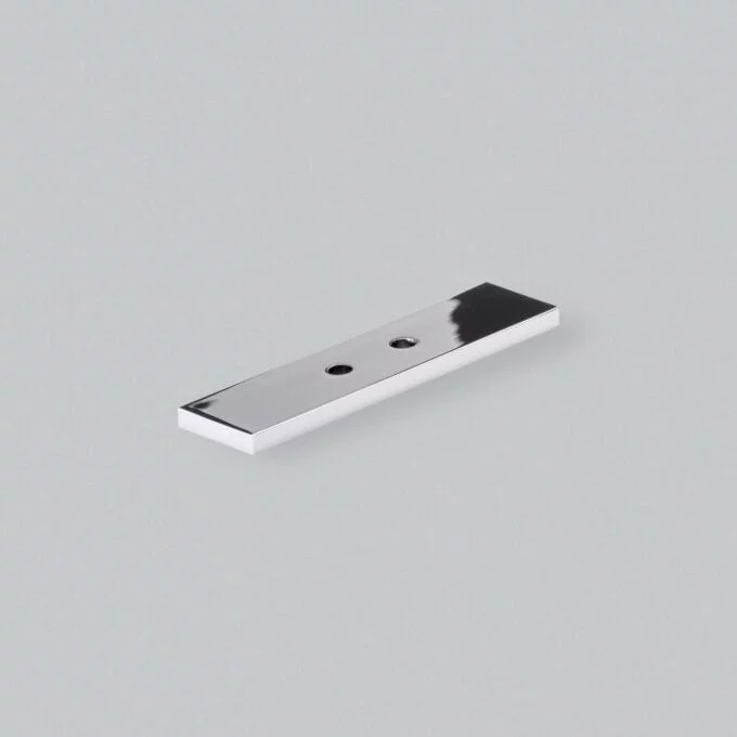 Chrome door handle plate on grey background.