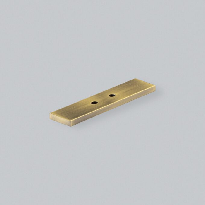 Brass door plate on light grey background.