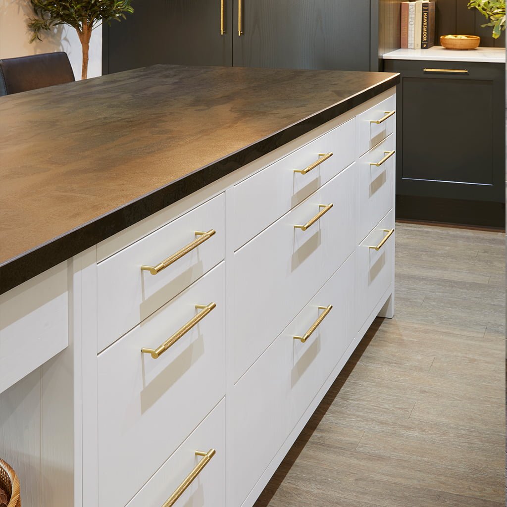 Modern kitchen with white cabinets and gold handles.