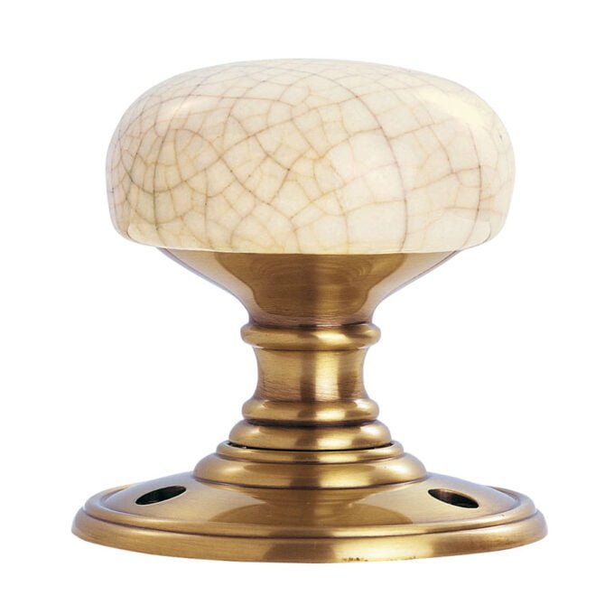 Ivory-coloured, crackle-effect cabinet knob on brass base.